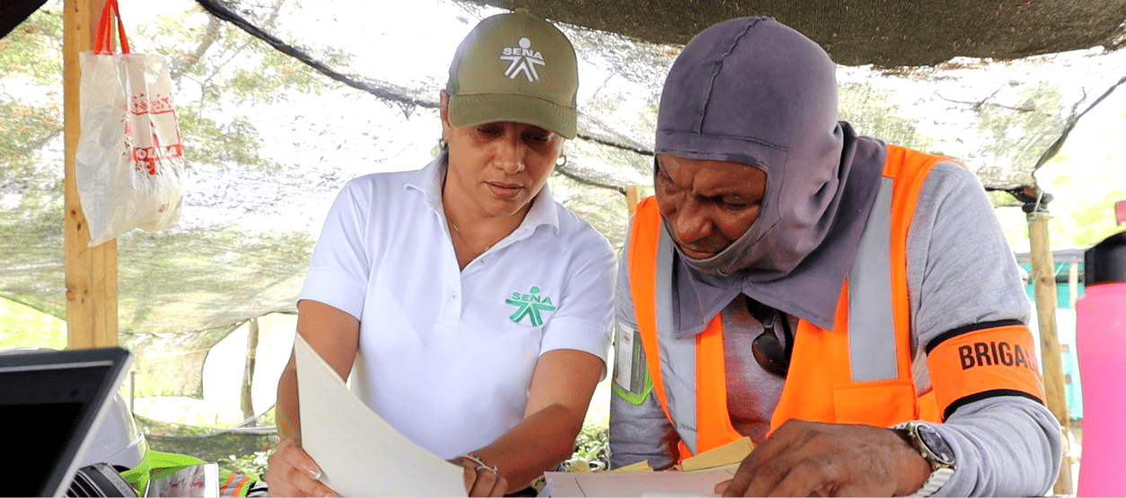 Instructora del SENA y trabajador brigadista revisan documentación en proceso de formación técnica en parque solar del Atlántico