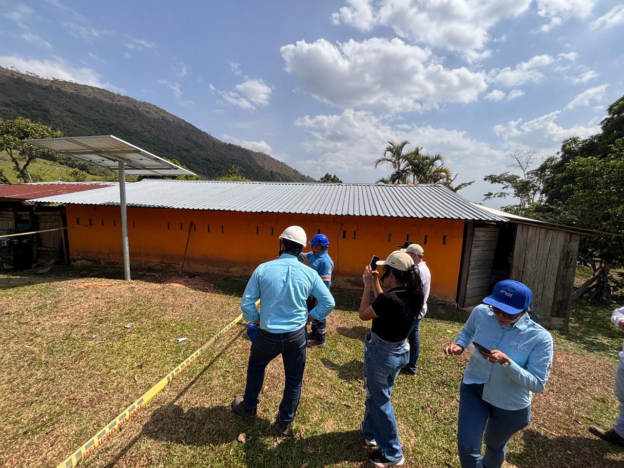 Equipo técnico realiza una visita de inspección junto a una vivienda rural con sistema de energía solar instalado