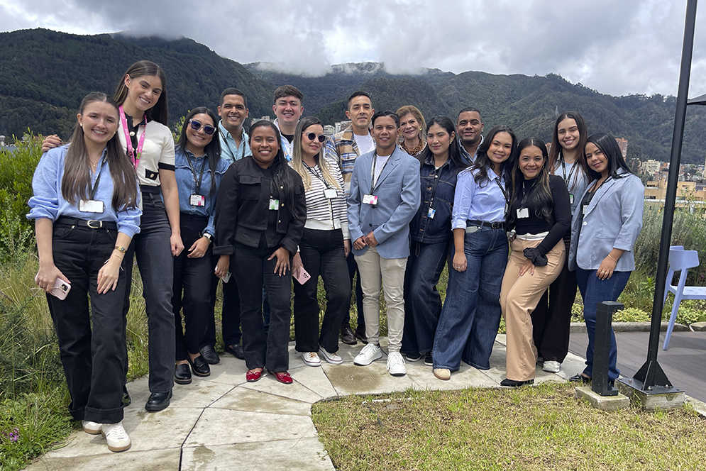 Grupo diverso de colaboradores de Enel reunido al aire libre frente a las montañas de Bogotá.