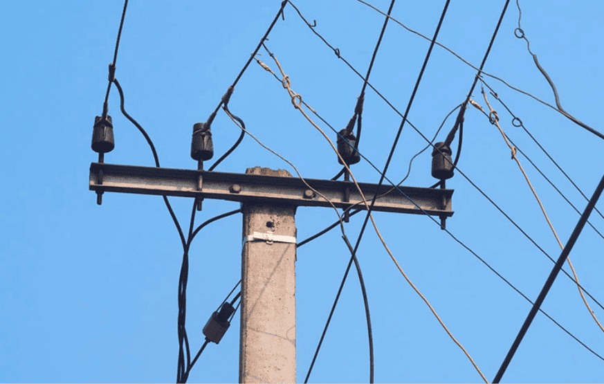 Persona manipulando cables eléctricos en un poste