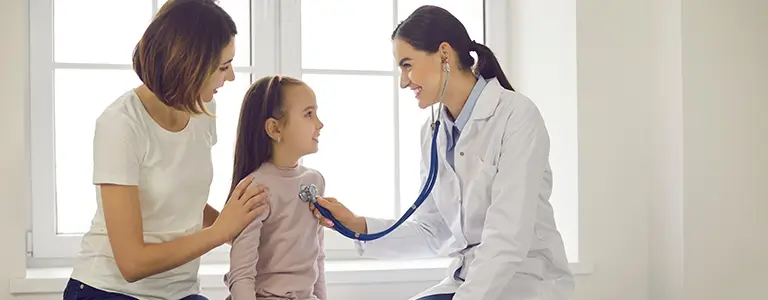 Doctora atendiendo a una niña junto a su madre en su domicilio