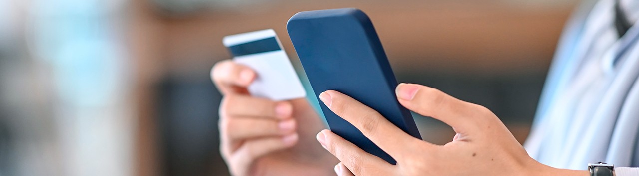 Person paying an Enel energy bill with a card and mobile phone – digital payments