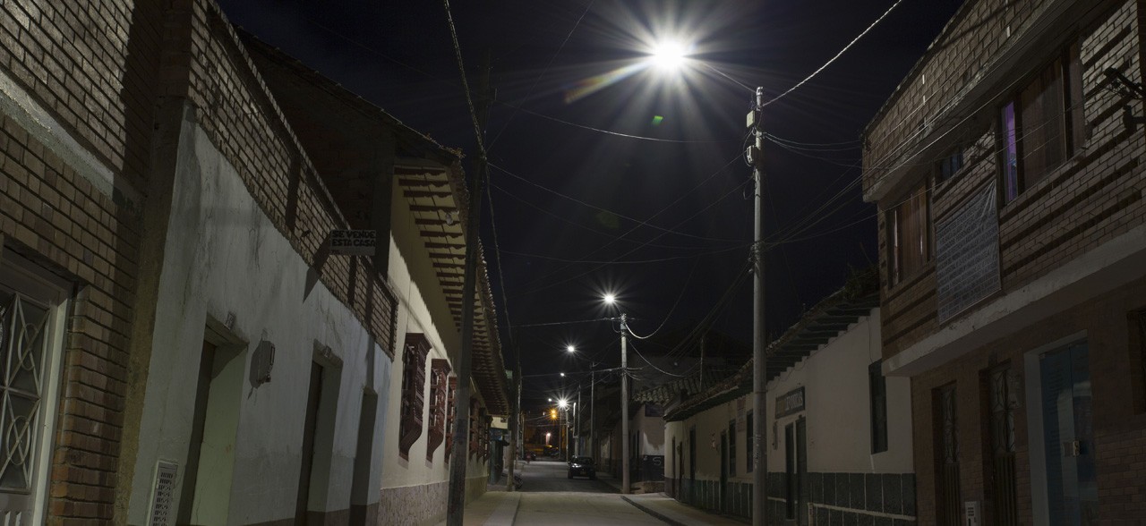 Calle residencial iluminada con sistema de alumbrado público en horario nocturno