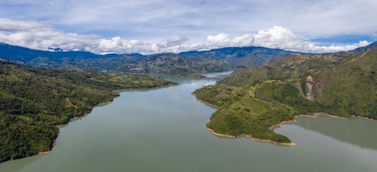 Paisaje de Colombia con río lleno de agua, que aporta a la generación de energía hidráulica.