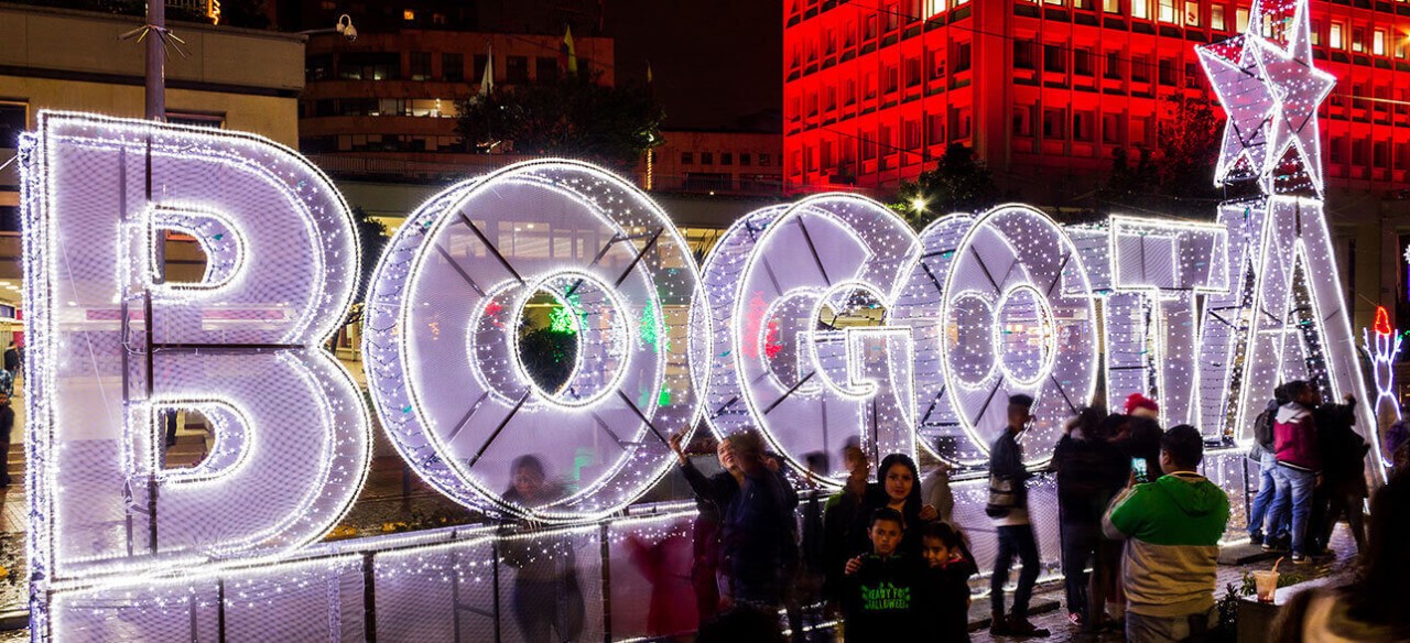 Personas tomándose fotos en los espacios iluminados con el alumbrado navideño en Bogotá.