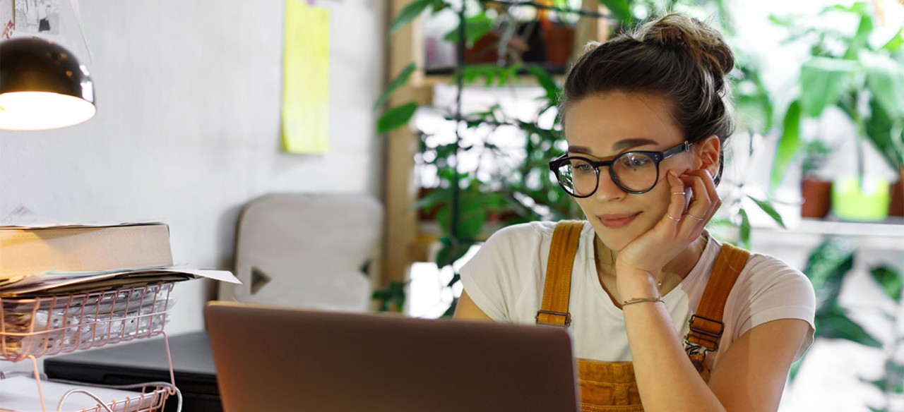 Mujer joven trabajando durante sus prácticas profesionales en su computador portátil.