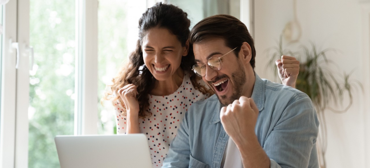 Un hombre y una mujer celebrando que ganaron la convocatoria Emprende con Enel.