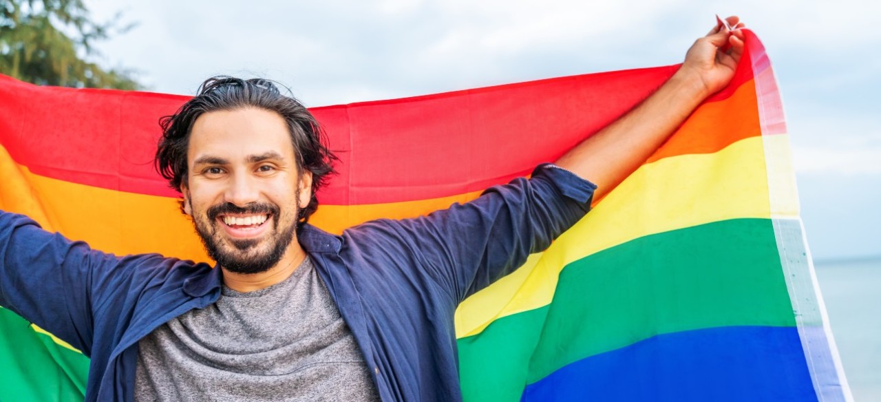 Joven sonriendo en el Día del Orgullo LGBTIQ+.