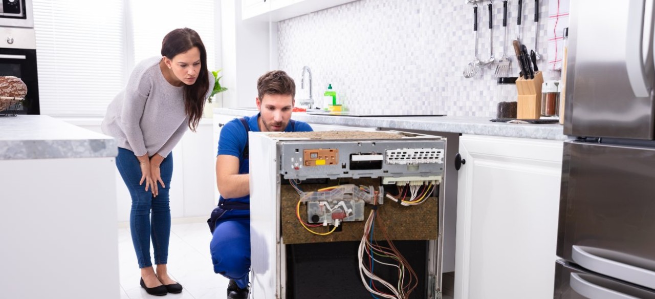 Mujer aprendiendo cómo cuidar los electrodomésticos en casa.