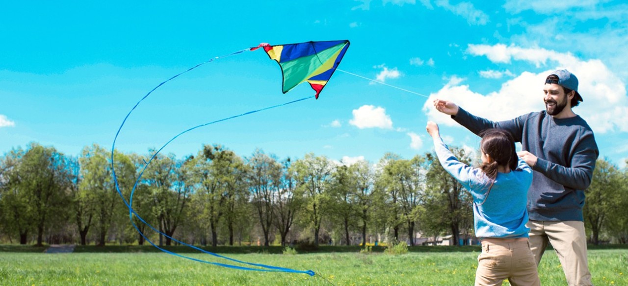 Hombre y niña volando cometa