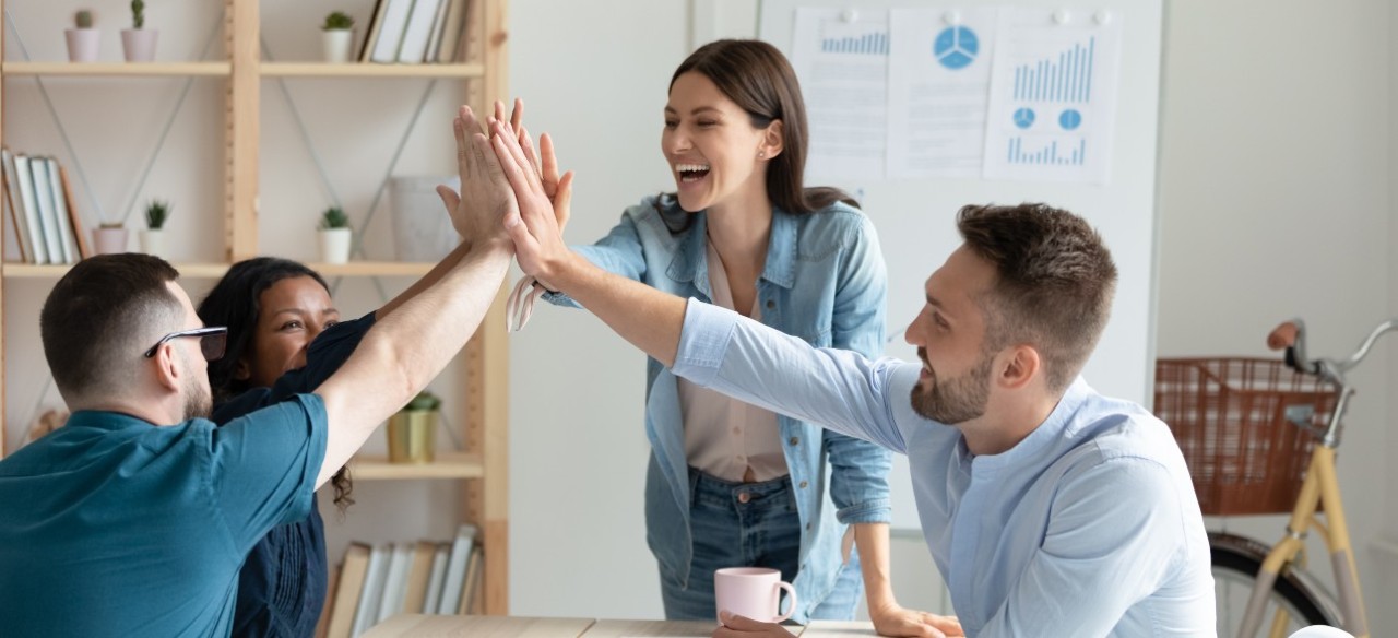 Equipo de trabajo feliz por las políticas de bienestar laboral.