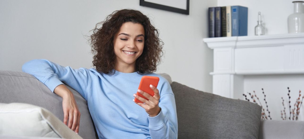 Mujer sentada en el sofa mirando el celular
