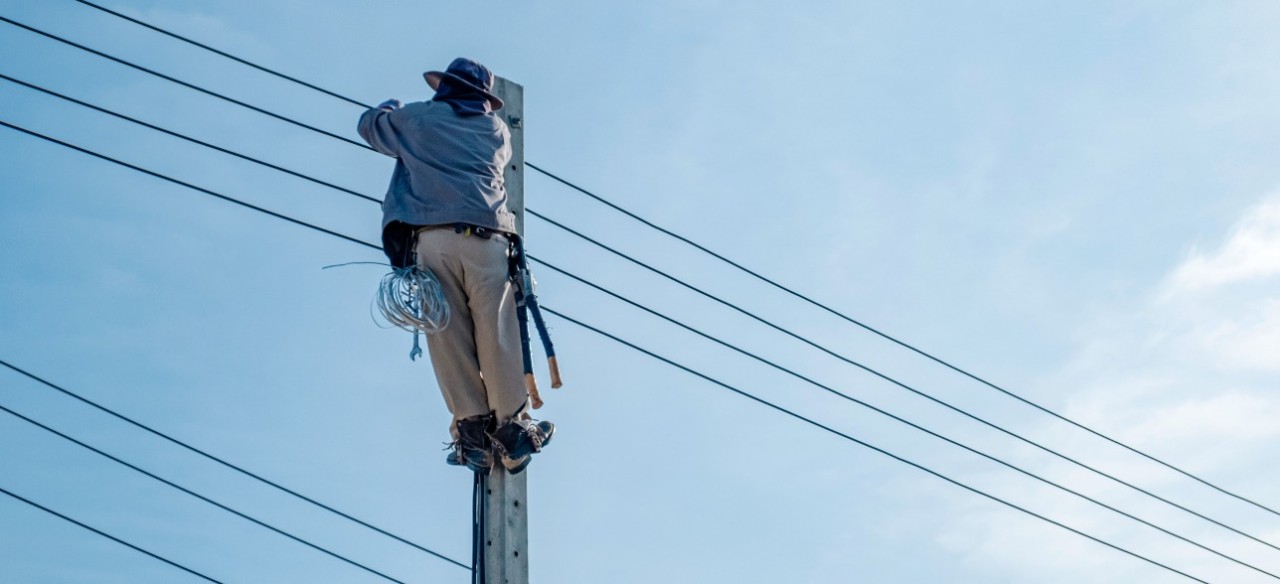 Hombre cometiendo hurto de energía eléctrica, lo cual conlleva sanciones por conexiones fraudulentas.