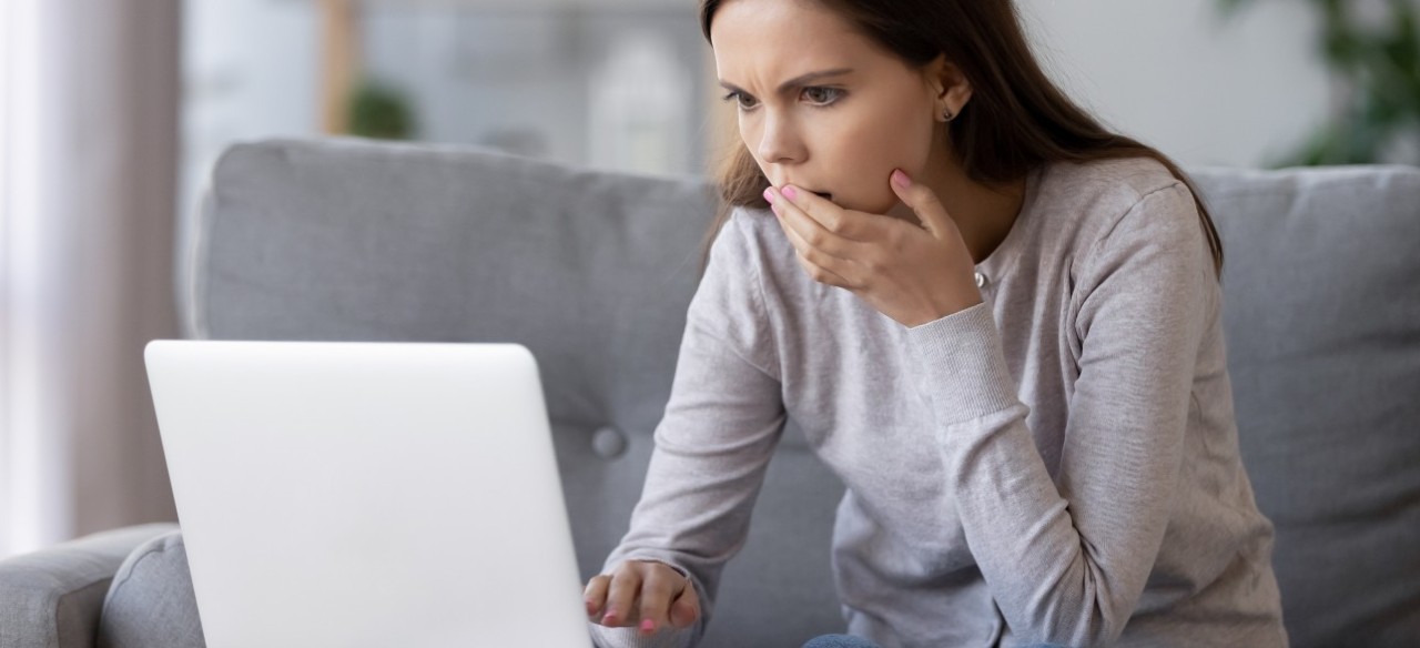 Mujer alertada de fraudes digitales al hacer pagos por internet.