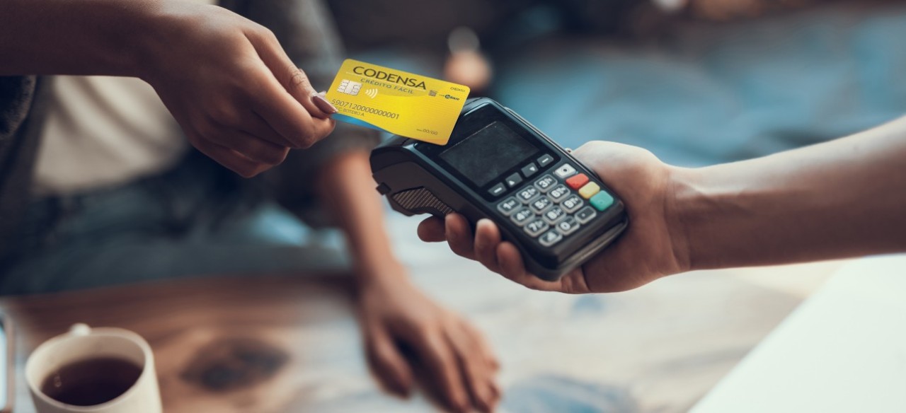 Mujer pagando con su tarjeta crédito fácil CODENSA en cualquier establecimiento comercial. 