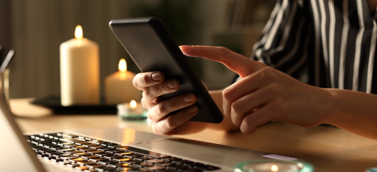 Una persona con su celular hace un reporte de fallas Enel