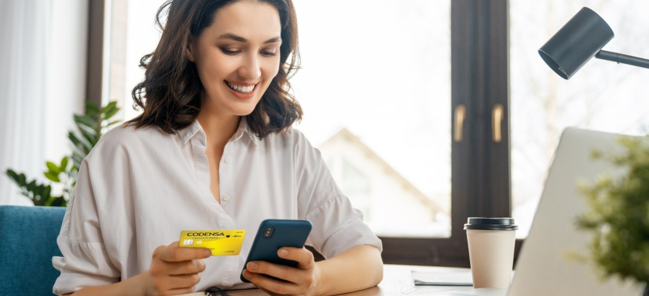 Mujer feliz por el buen manejo financiero y de mejorar su historial crediticio.