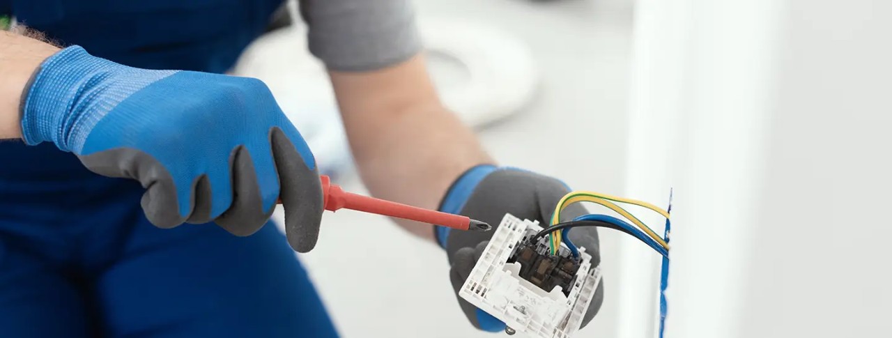 Hombre solucionando una falla en las instalaciones eléctricas residenciales, gracias a Enel