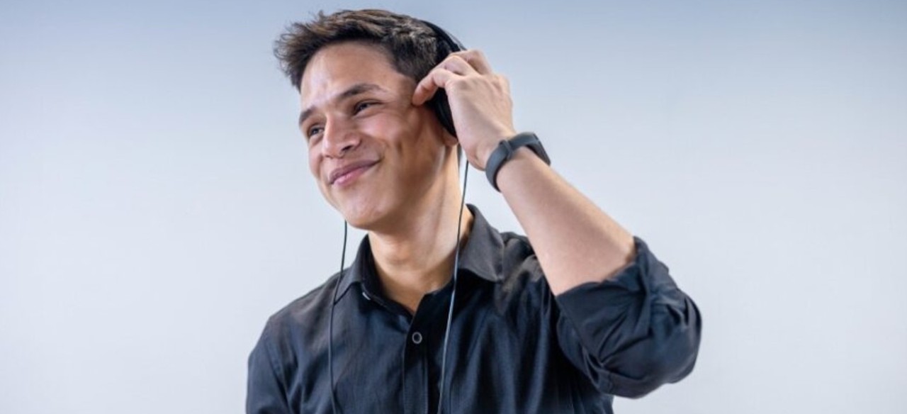 Joven que hace sus prácticas laborales en Enel Colombia, escuchando música.