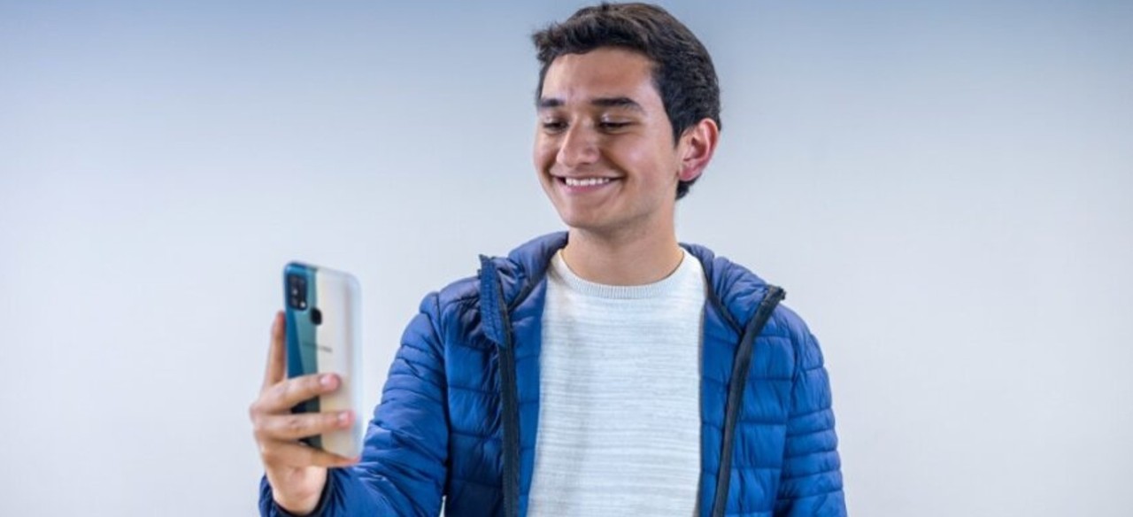 Joven feliz de hacer sus prácticas profesionales en una empresa con posibilidad de crecimiento laboral.