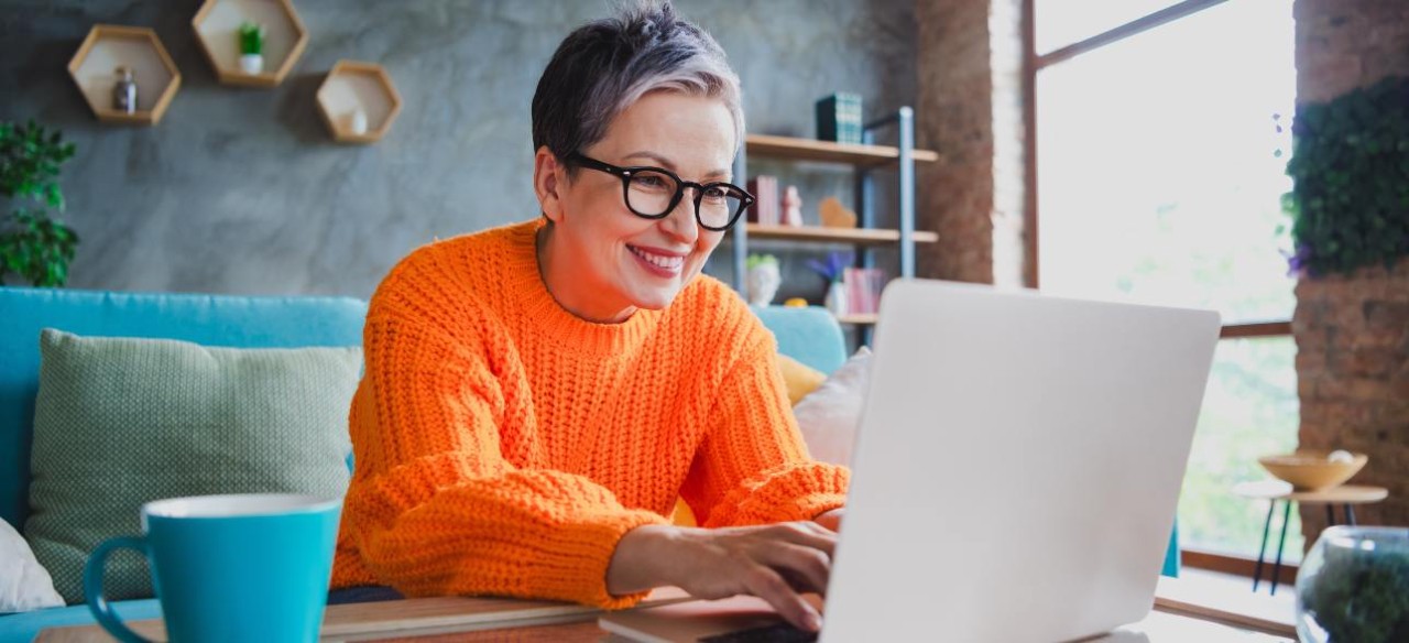 Mujer consultando su factura de energía en línea para hacer trámites relacionados más fácil y rápido. 