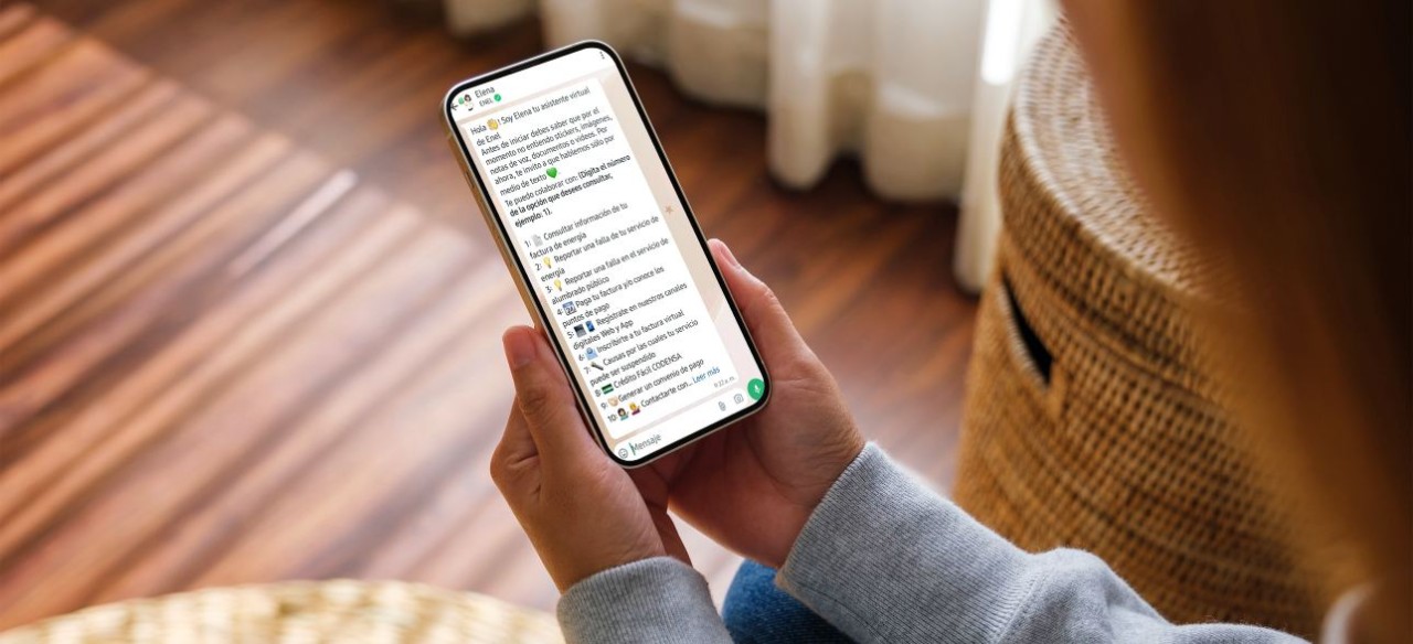 Mujer realizando consultas de su factura Enel a través de WhatsApp Elena.