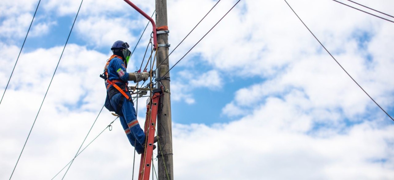 Técnico de Enel Colombia realizando servicio de instalación de una nueva conexión de energía.