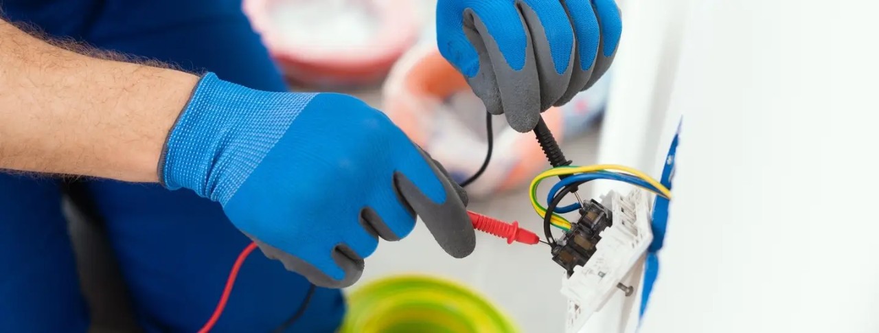 Electricistas certificados por Enel realizando obras eléctricas en un hogar, según el RETIE.