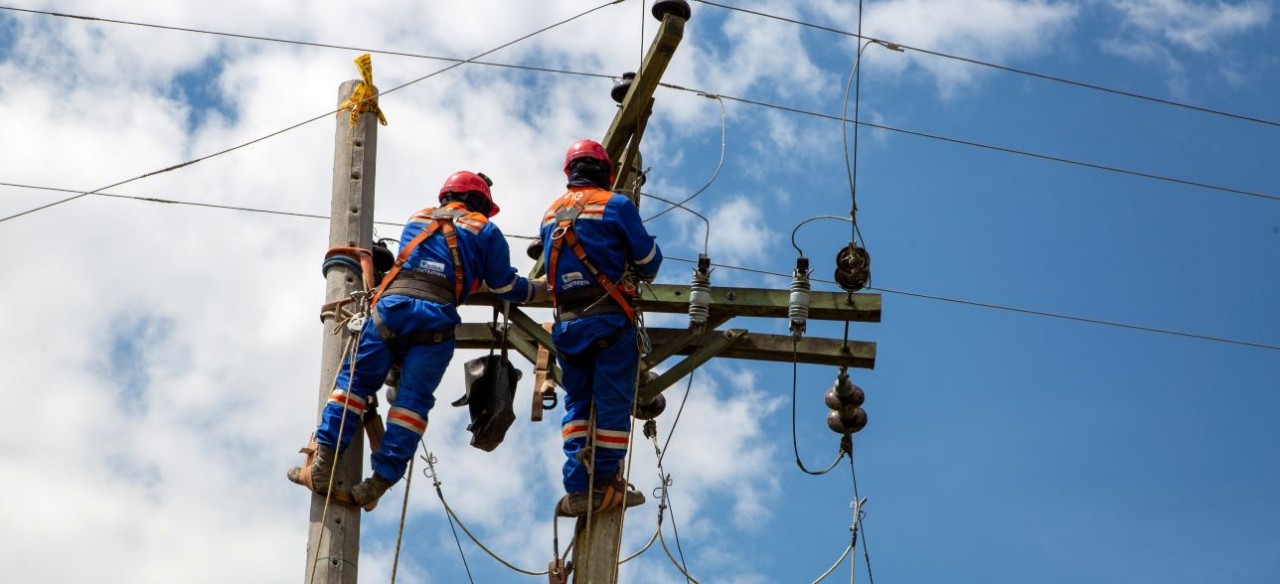 Técnicos de Enel en poste de luz