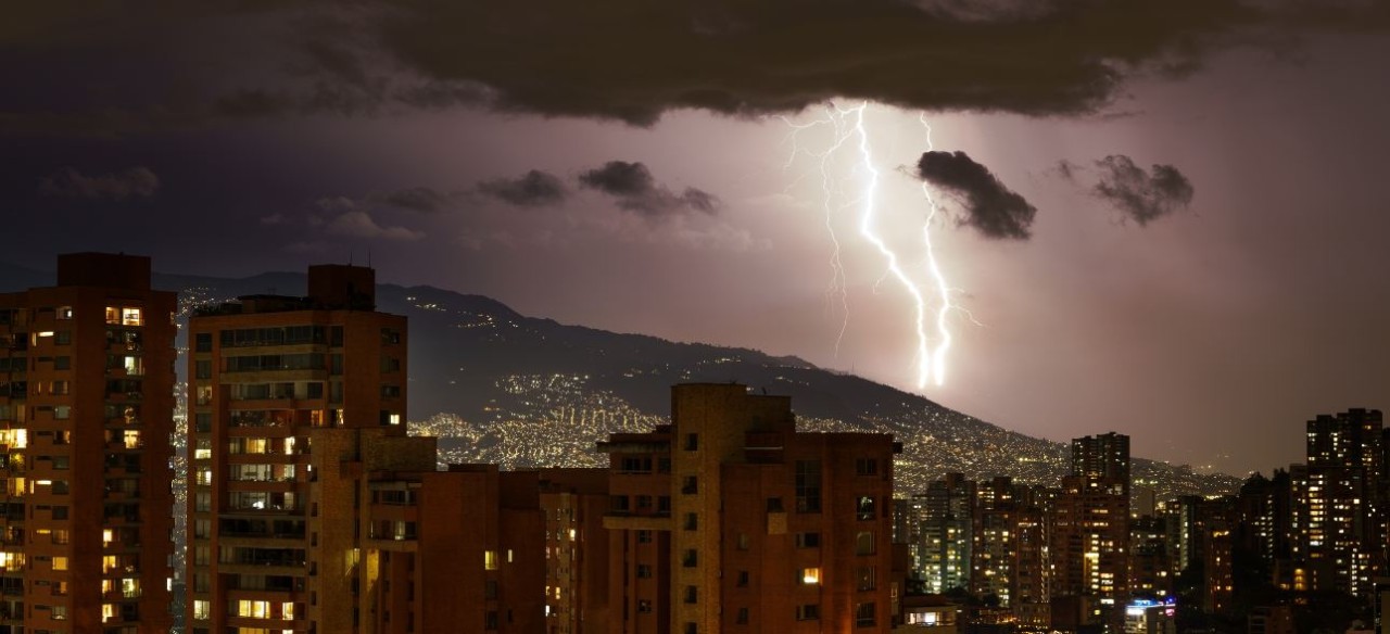 Tormenta nocturna con descargas atmosféricas que iluminan el cielo de la ciudad.