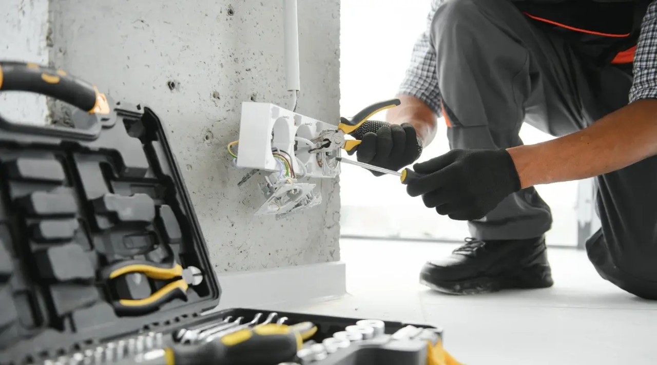 Hombre haciendo mantenimiento al sistema eléctrico para prevenir un cortocircuito