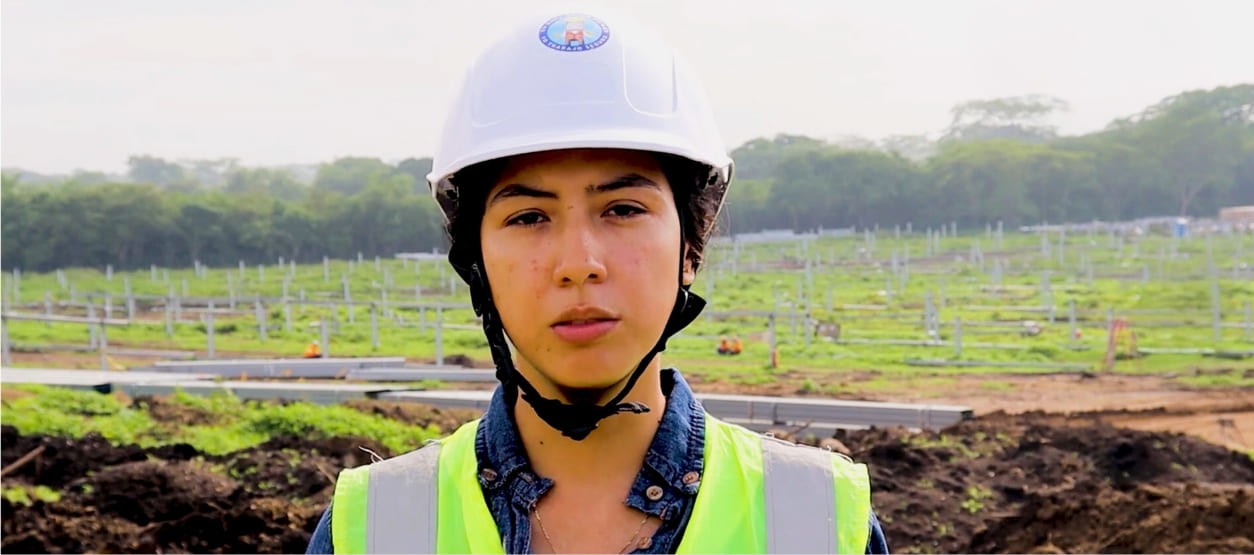 Mujer con casco y chaleco de seguridad en un proyecto solar de Enel en Colombia 