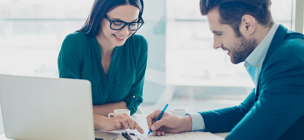 Dos personas revisando el reglamento de comercialización de energía eléctrica de Enel Colombia
