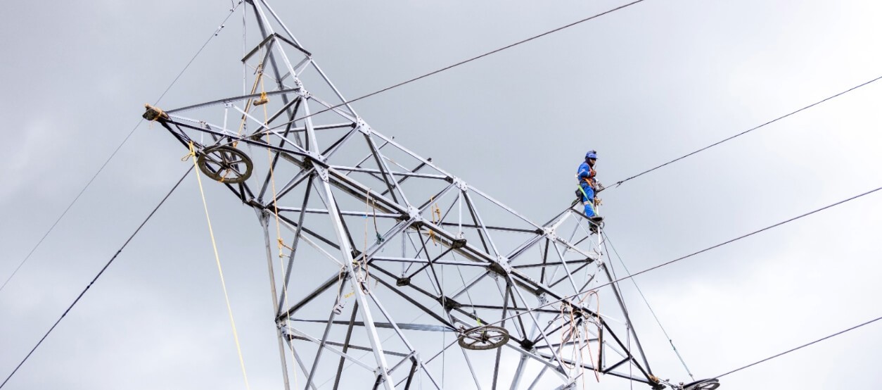 Técnico Enel con arnés trabajando en torre de alta tensión 115 kV – repotenciación Sabana Norte Cundinamarca