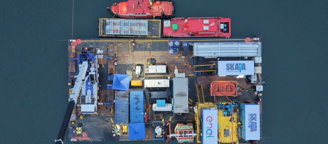 Plataforma flotante con equipos técnicos durante mantenimiento subacuático en la central El Guavio