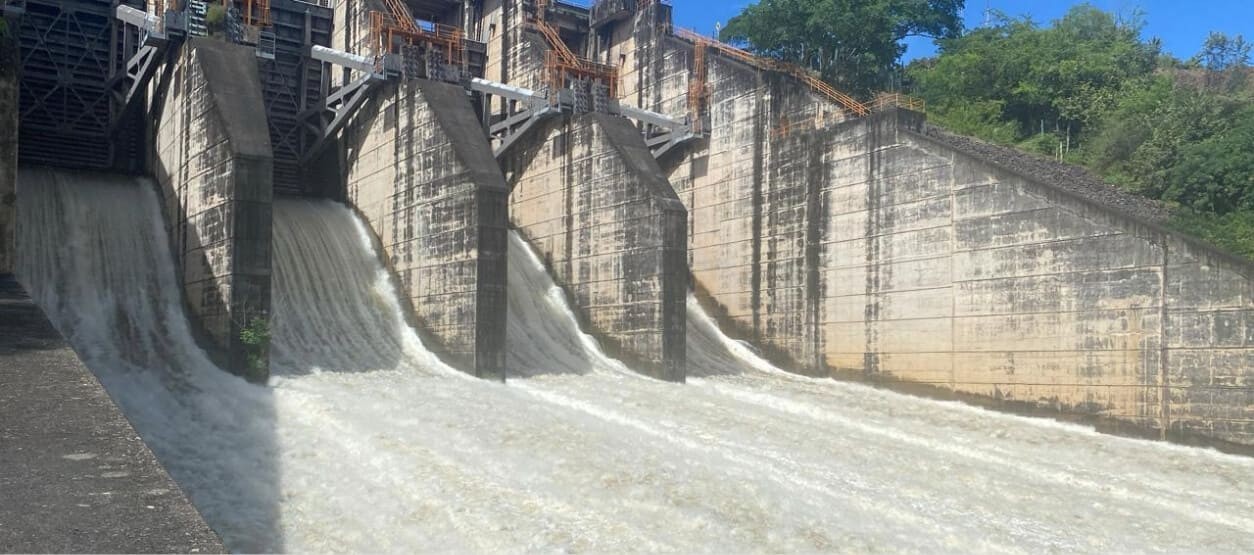 Vista general de la represa de la Central Betania con descarga de agua por compuertas.