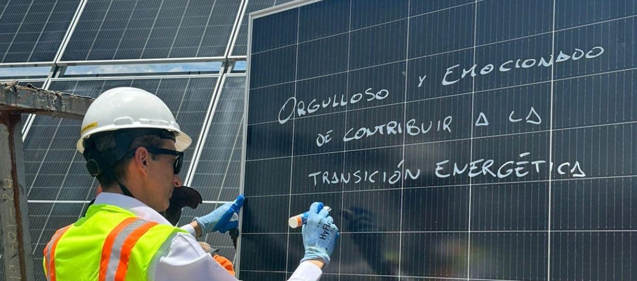 Trabajador de Enel Colombia frente a paneles solares durante actividades de operación en parque fotovoltaico.