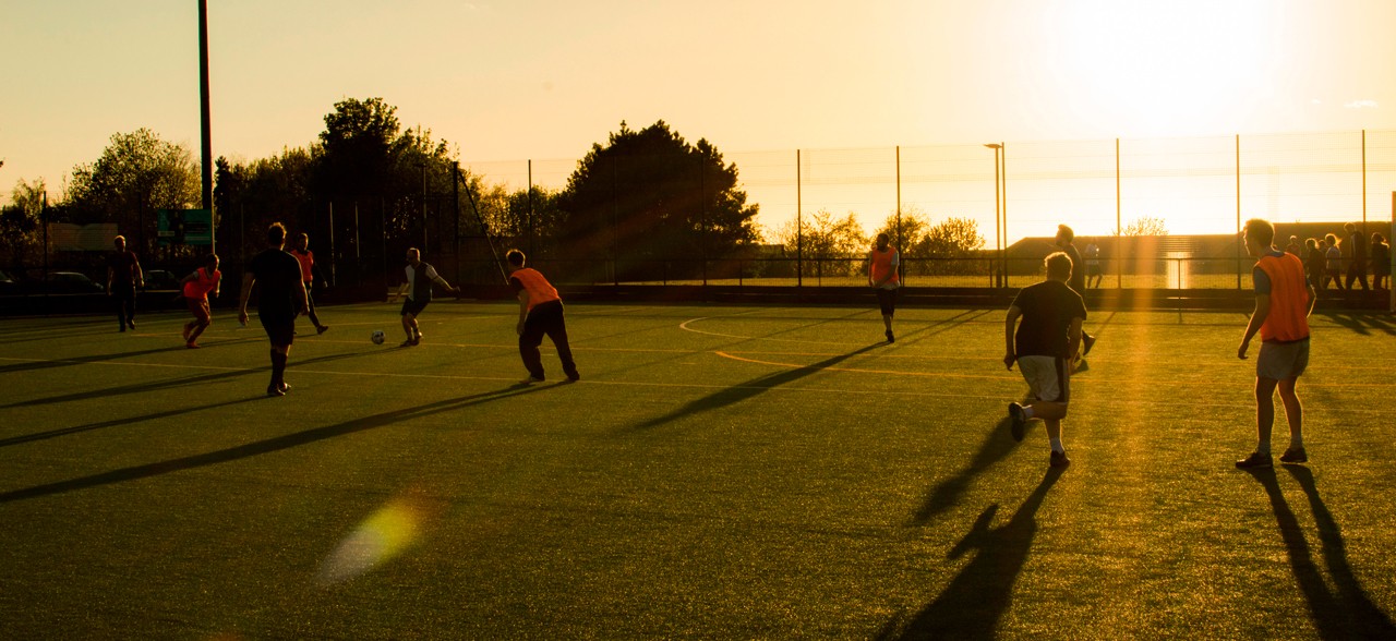 Estudiantes juegan fútbol en una cancha al aire libre durante el cierre de la entrega de dotación deportiva.
