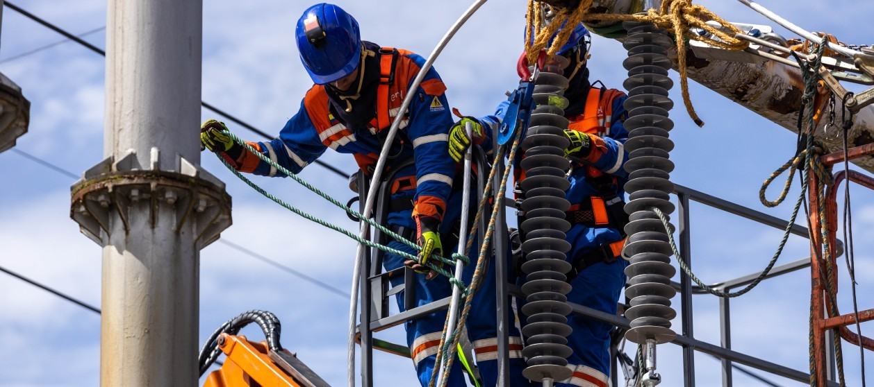 Trabajadores de ENEL arreglando cables en un poste